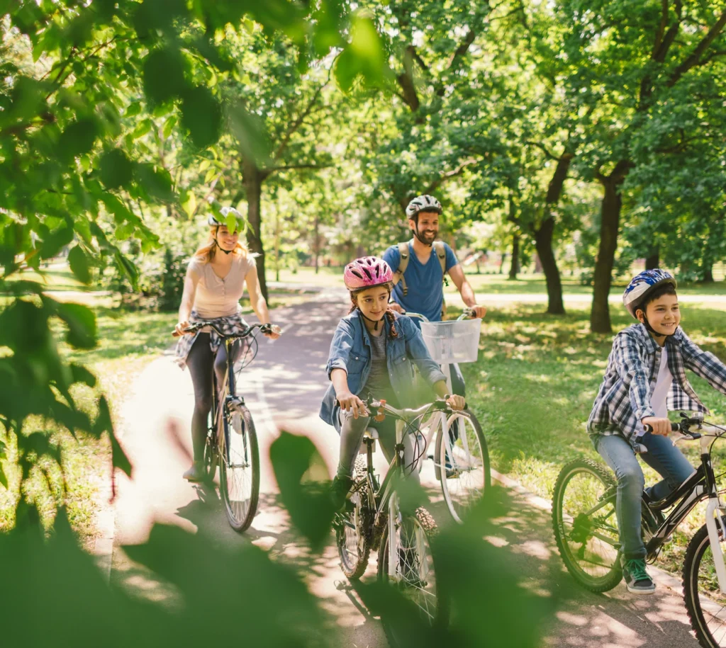 Family of four biking on path.